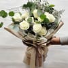 Bouquet of white roses with eucalyptus in tan wrapping
