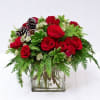 cube with red green and white flowers arranged with pine cones 