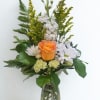 A single orange rose-warm, optimistic, and the immediate focal point-crowns this Fresh