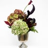 Hydrangea arrangement with dark calla lilies in a glass vase