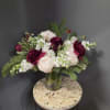 Bouquet of blush and burgundy flowers in a clear glass vase