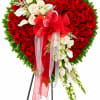Heart-shaped red rose arrangement with white flowers and a red ribbon bow