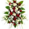 Standing floral spray with red and white flowers on a white easel
