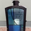 Decorative memorial lantern with blue glass panels and a sympathy message