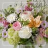 Mixed bouquet of roses, lilies, hydrangeas, and daisies in a glass vase
