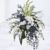 Tall floral spray with white and blue flowers and cascading greenery