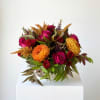 Bouquet of magenta roses and orange chrysanthemums with autumn foliage