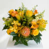 Yellow and orange floral arrangement in a glass vase