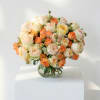 Peach and cream roses arranged in a clear glass vase