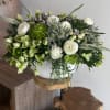 White and green floral arrangement in a white vase