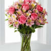 A rounded cluster of soft pink roses and pink alstroemeria makes a
