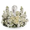 White floral arrangement with roses and a praying angel figurine