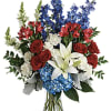 Bouquet of red roses, white lilies, blue flowers, and white blooms in a glass vase