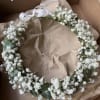 White baby's breath floral crown with ribbon ties in a box