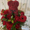 Red rose teddy bear with a gold crown, surrounded by red roses and gerbera daisies