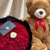 Bouquet of red roses with a white rose and a teddy bear