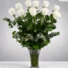 Tall bouquet of white roses in a clear glass vase