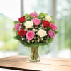 Bouquet of red, pink, and white roses in a clear glass vase