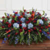A large, low casket spray designed for a sympathy or funeral tribute