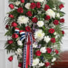 A dignified standing spray crafted in a solemn red, white and blue