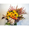 Autumn arrangement with sunflowers, berries, and fall leaves in a vase