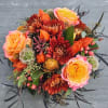 Bouquet of orange and pink roses with red chrysanthemums and mixed accents
