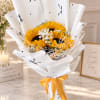 Bouquet of sunflowers wrapped in white paper with a yellow ribbon