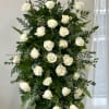 Tall standing arrangement of white roses and greenery on a black easel