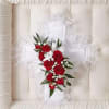 White lace pillow with a red rose bouquet tied on top