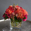 Bouquet of red and orange flowers in a clear glass vase