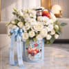 White rose arrangement in a blue decorated box with an apple and ribbon