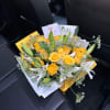 Yellow roses and white lilies in a wrapped bouquet
