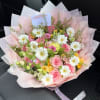 Pink and white mixed bouquet with daisies and roses wrapped in pale pink paper