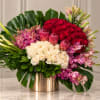 Large bouquet of red and white roses with pink orchids in a gold vase