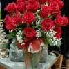Bouquet of red roses in a glass vase with a red ribbon