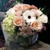 Bouquet of pale roses, hydrangea, and a white gerbera daisy in a glass vase
