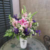 Pink lilies and purple flowers in a white vase