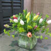 Mixed tulips arranged in a clear square glass vase