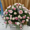 Large pink and white floral standing spray on a metal easel