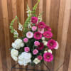Tall arrangement of hot pink gerberas, pink roses, white hydrangeas, and green bells of Ireland.