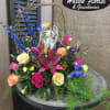 Colorful floral arrangement with roses, lilies, and an angel figurine