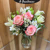 Pink roses and white lilies in a clear glass vase