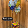 Birthday balloons above a colorful flower arrangement in a vase