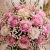 A romantic vase bouquet featuring pink and ivory roses, delicate baby&rsquo;s breath