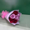 Bouquet of red and lavender roses wrapped in pink paper
