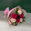 Bouquet of pink and blush roses with baby's breath wrapped in pink paper