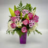 Pink roses and white lilies arranged in a purple vase
