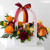 Flower gift box with orange roses, chrysanthemums, and a gold candle jar