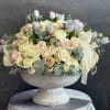 Cream and blush rose bouquet with pastel tulips in a pedestal vase