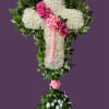 White floral cross with pink roses and ribbon on a purple background